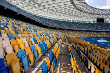Sarı ve mavi bankları olan olimpiyat stadyumunda boş koltuklar.