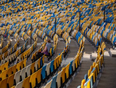 Sarı ve mavi bankları olan olimpiyat stadyumunda boş koltuklar.