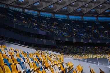 Sarı ve mavi bankları olan olimpiyat stadyumunda boş koltuklar.