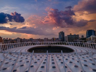 Şehirdeki futbol stadyumunun hava manzarası gün batımının ve güzel bulutların arkaplanına karşı.