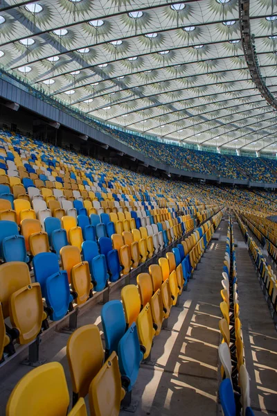 Puste Rzędy Miejsc Stadionie Piłkarskim Żółtymi Niebieskimi Ławkami — Zdjęcie stockowe