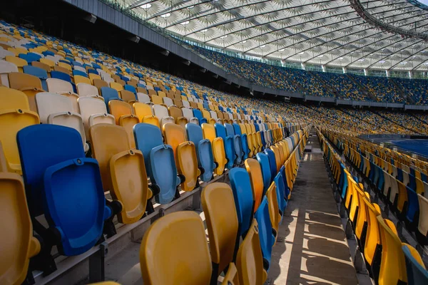 Puste Rzędy Miejsc Stadionie Piłkarskim Żółtymi Niebieskimi Ławkami — Zdjęcie stockowe