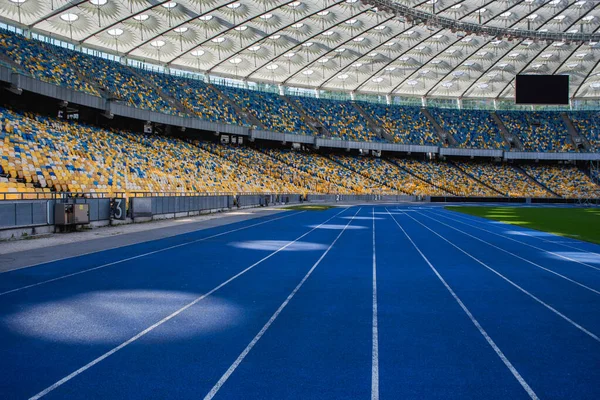 Üres Kék Futópálya Olimpiai Stadionban Üres Standok Hátterében — Stock Fotó