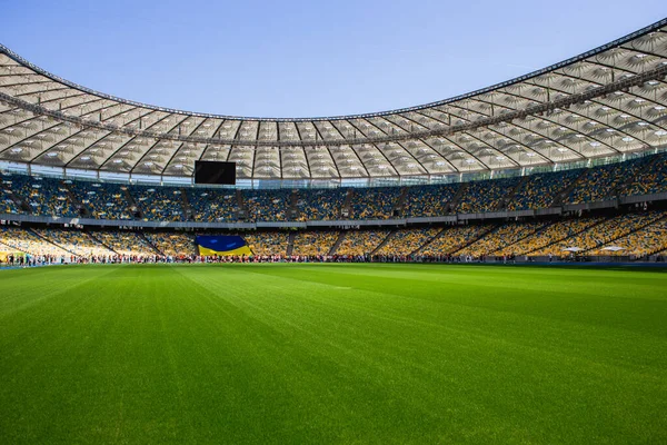 Ukrayna bayrağı ve futbol olimpiyat stadyumunda sarı ve mavi banklarla kalabalık