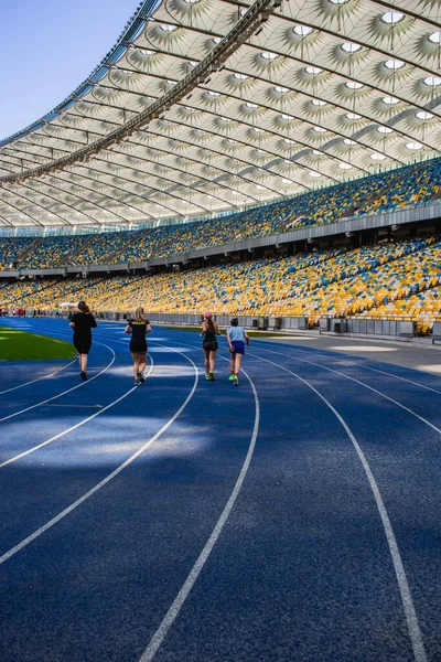 Sportovci Běží Prázdné Modré Běžecké Dráze Olympijském Stadionu Pozadí Prázdných — Stock fotografie