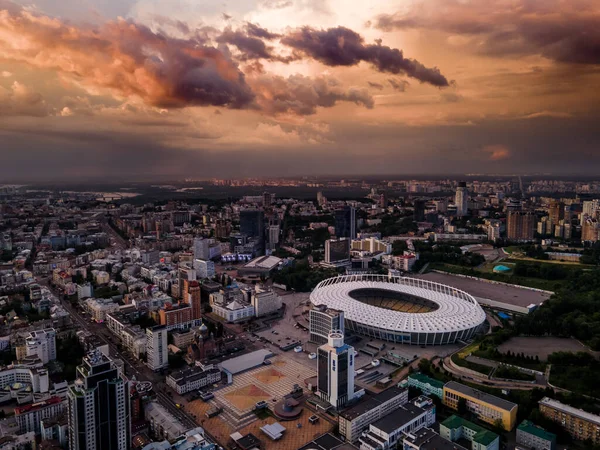 Şehirdeki futbol stadyumunun hava manzarası gün batımının ve güzel bulutların arkaplanına karşı.