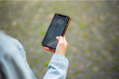 Beyaz eli avucunda cep telefonu tutan bir kadın.