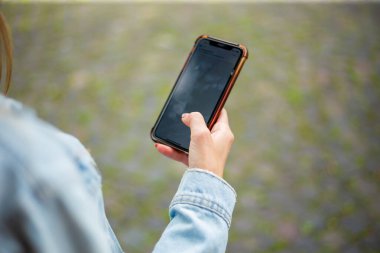 Beyaz eli avucunda cep telefonu tutan bir kadın.