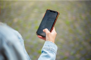 Beyaz eli avucunda cep telefonu tutan bir kadın.