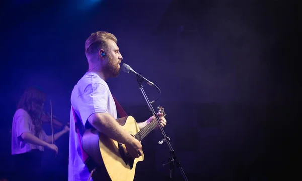 Jovem Uma Camiseta Branca Com Barba Segura Uma Guitarra Acústica — Fotografia de Stock