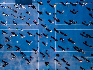 Koşu yolunda fiziksel egzersiz yapan bir grup insanın insansız hava görüntüsü.