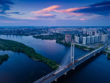 Akşamları nehir kıyısındaki bir köprüde insansız hava aracı görüntüsü.