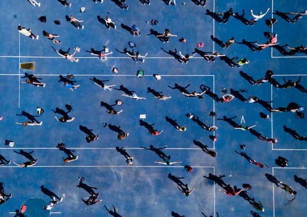 Vista aerea da un drone di un gruppo di persone che fanno esercizio fisico su una pista da jogging — Foto Stock