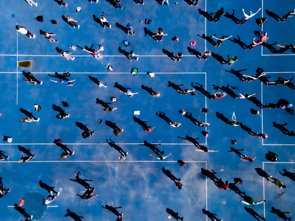 Luftaufnahme von einer Drohne einer Gruppe von Menschen, die körperliche Bewegung auf einer Joggingstrecke ausüben — Stockfoto
