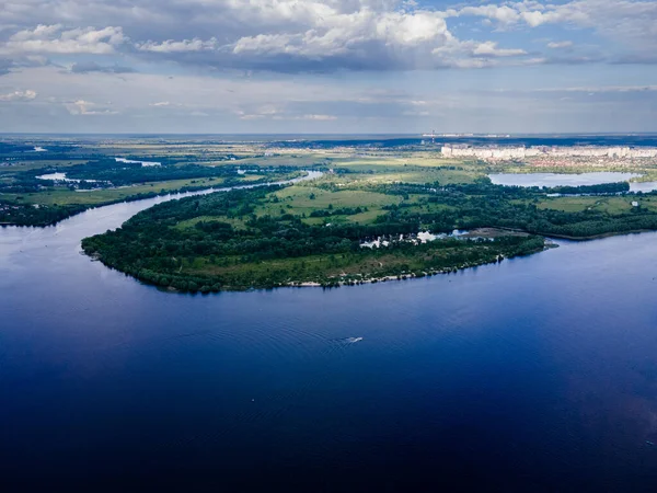 Yaz mevsiminde yeşil bir çayırda taze bir nehirde insansız hava aracı görüntüsü.