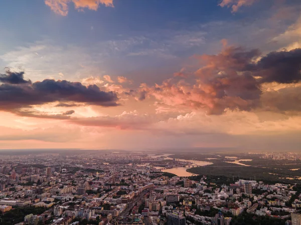 Vista aérea sobre las nubes de lluvia al atardecer sobre la ciudad — Foto de Stock