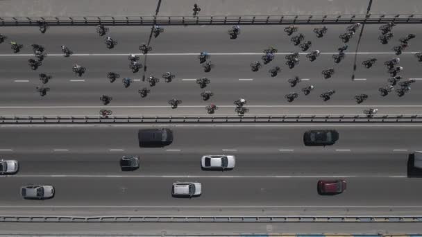 Letecký pohled z dronu na skupinu cyklistů na projížďce na silnici s dopravou — Stock video