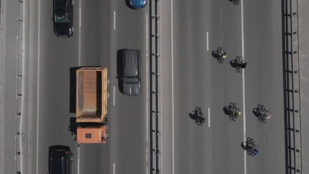 从无人驾驶飞机到骑自行车的一群骑自行车的人的空中景观在路上飞驰 — 图库视频影像