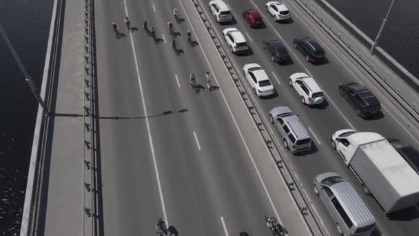 드론에서 도로를 달리는 자전거를 타고 있는 일단의 자전거타는 사람들을 향해 공중에서 내려다본 모습 — 비디오