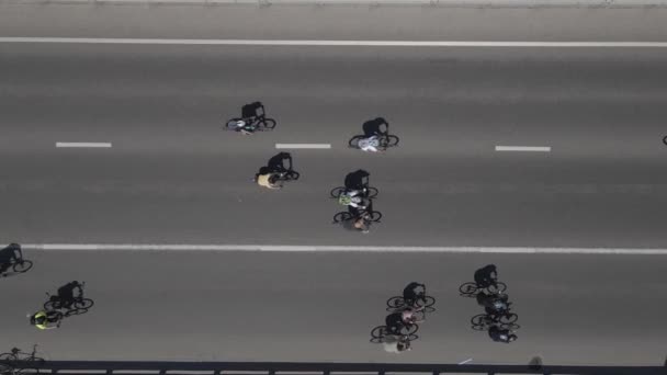 Vista aérea desde un avión no tripulado a un grupo de ciclistas en bicicleta en la carretera con tráfico — Vídeo de stock