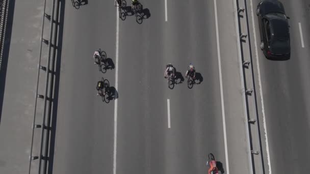 Vue aérienne d'un drone à un groupe de cyclistes à vélo sur la route avec la circulation — Video