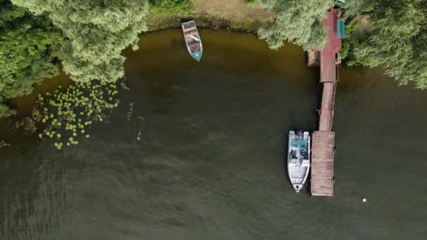 Vista aérea do drone de um barco ancorado em um cais de madeira no rio — Vídeo de Stock