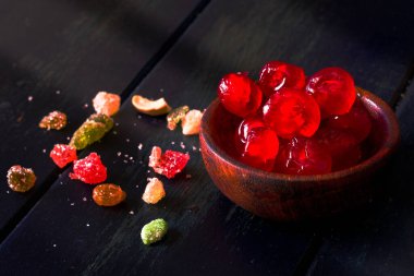 Koyu mavi bir masada kirazlı ahşap bir kase. Noel zamanı.