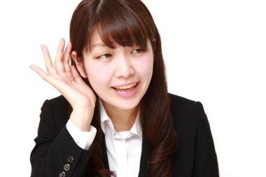 yakından dinlerken kulak arkasında el ile genç iş kadını