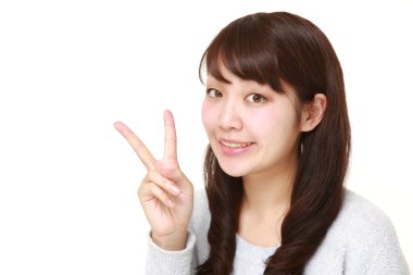 zafer işaret gösteren genç Japon kadın