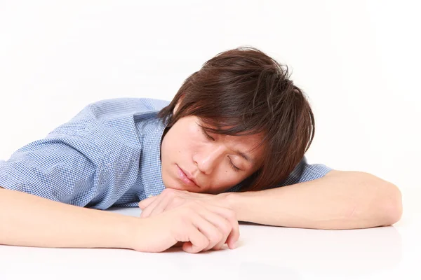 Joven durmiendo sobre la mesa — Foto de Stock