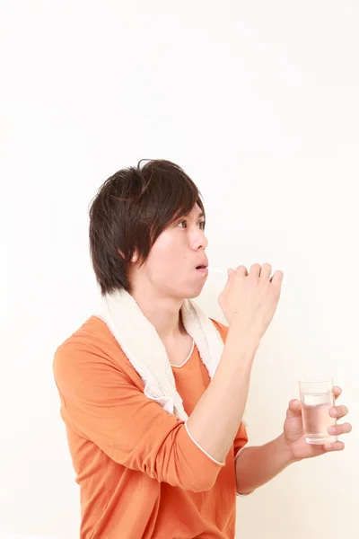 Young Japanese man brushes teeth — Stock Photo, Image