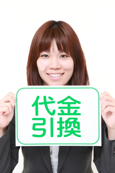 Affärskvinna innehar en anslagstavla med frasen Postförskott i Kanji — Stockfoto