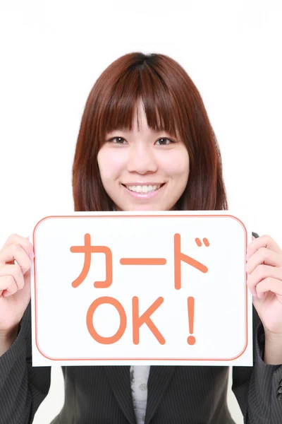 Bizneswoman gospodarstwa forum kartą kredytową frazę, akceptowane w języku japońskim — Zdjęcie stockowe