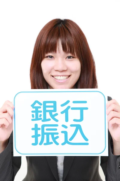 Zakenvrouw houden een message board met de woordgroep bank transfer in Kanji — Stockfoto