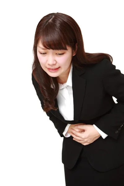 Joven japonesa mujer de negocios sufre de dolor de estómago — Foto de Stock