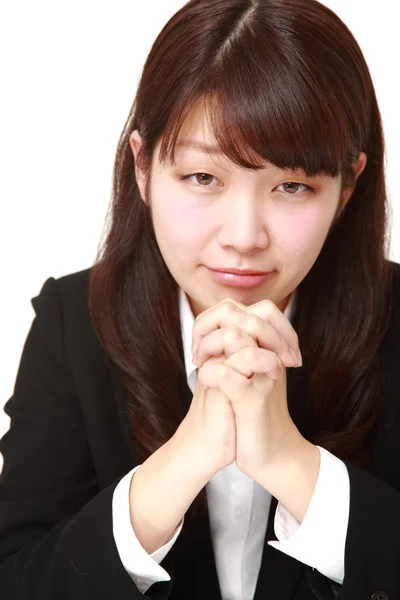Joven mujer de negocios japonesa doblando sus manos en oración —  Fotos de Stock