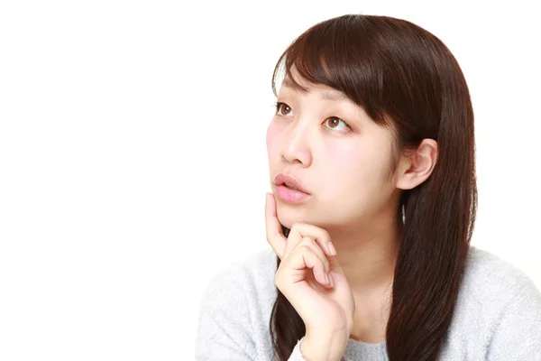 Young Japanese woman thinks about something — Stock Photo, Image