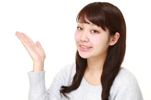 Young Japanese woman presenting and showing something — Stock Photo, Image