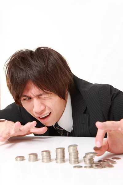 Stack of coins collapsed when businessman put a coin Stock Picture