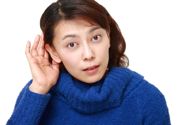 Mujer con la mano detrás de la oreja escuchando atentamente — Foto de Stock