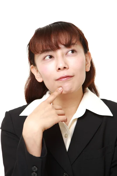Asiática mujer de negocios piensa en algo —  Fotos de Stock