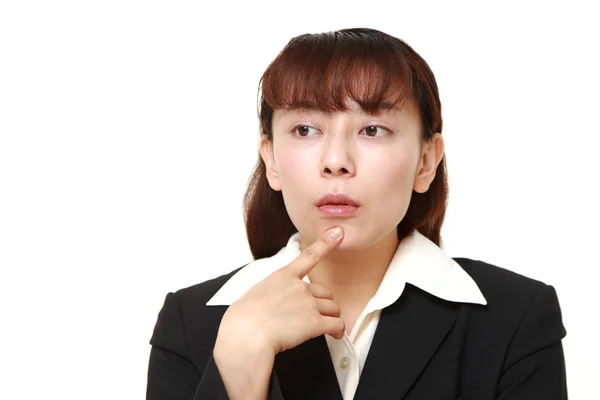 Asiática mujer de negocios piensa en algo — Foto de Stock