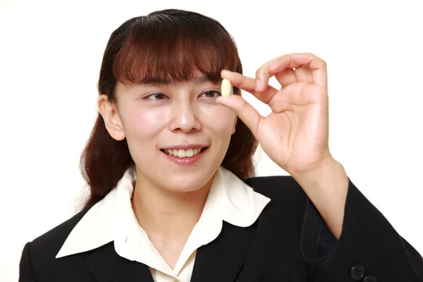 Asiática mujer de negocios toma un suplemento — Foto de Stock