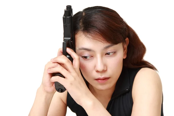 Woman with a handgun thinks — Stock Photo, Image