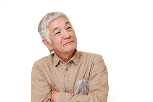 Старший японский человек думает о чем-то — стоковое фото