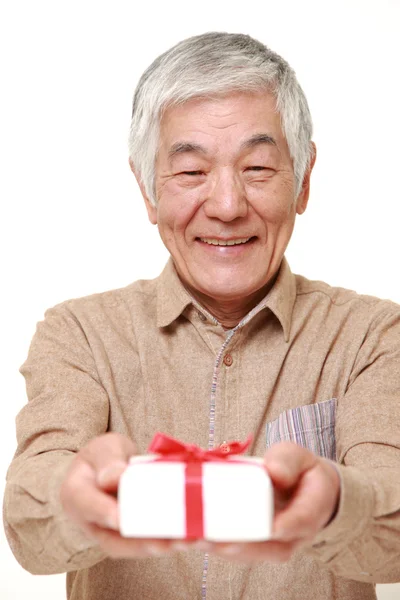 Sênior japonês homem oferecendo um presente — Fotografia de Stock