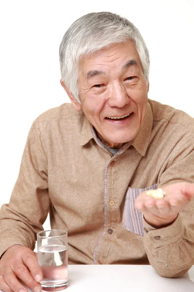 Sênior japonês homem toma um suplemento — Fotografia de Stock