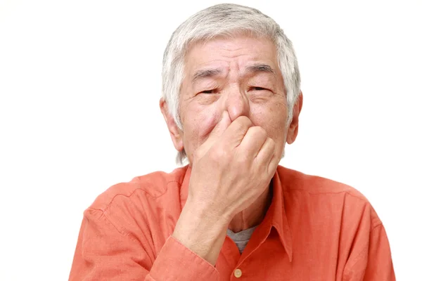 Senior japonés hombre sosteniendo su nariz a causa de un mal olor — Foto de Stock