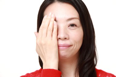 Japon kadın eliyle bir göz kapsayan