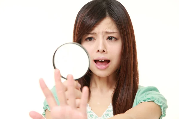 Sorprendido joven japonesa mujer mirando sus uñas —  Fotos de Stock